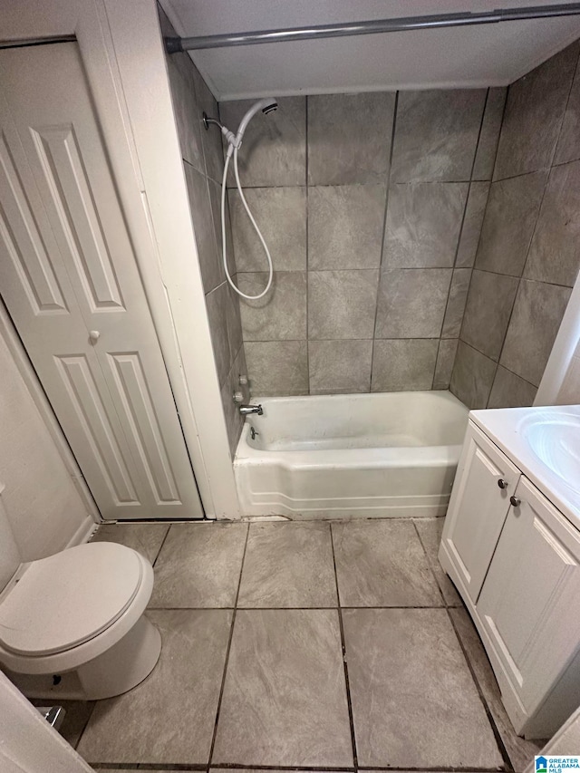 full bathroom featuring tiled shower / bath combo, vanity, toilet, and tile patterned flooring