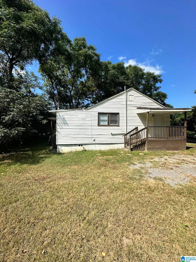 back of house with a deck and a lawn