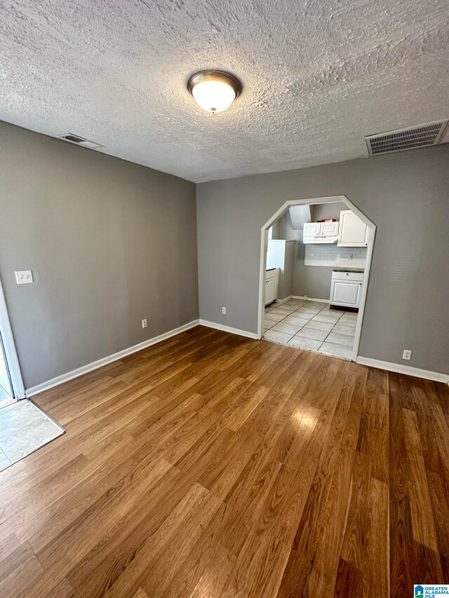 unfurnished bedroom featuring a textured ceiling and light hardwood / wood-style floors