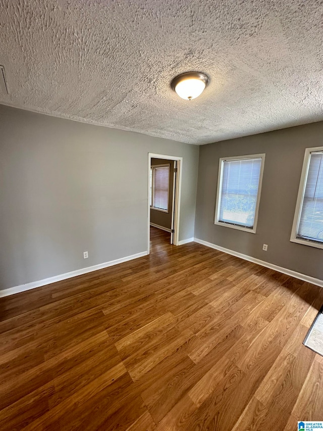 empty room featuring hardwood / wood-style flooring and a textured ceiling