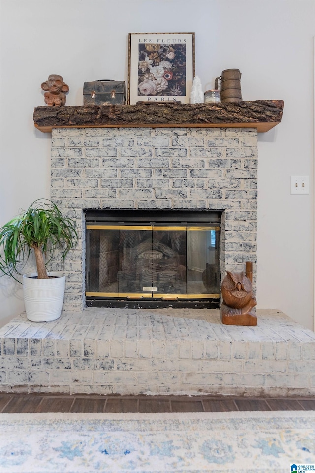 room details with a brick fireplace and hardwood / wood-style flooring