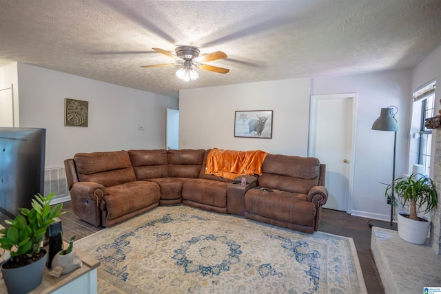 living room featuring hardwood / wood-style floors, ceiling fan, and a textured ceiling