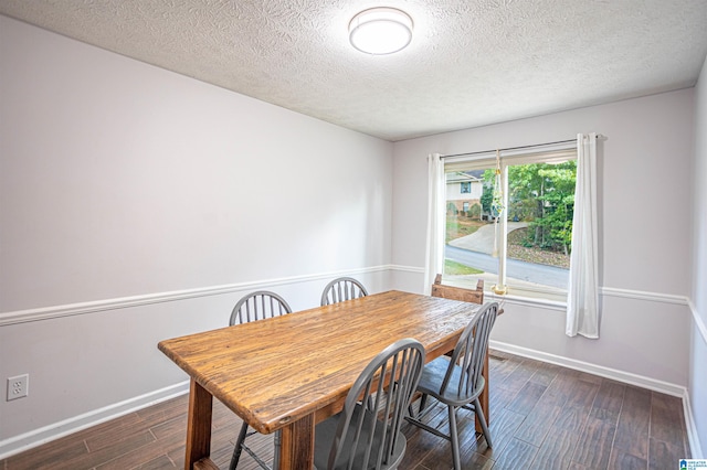 dining room featuring a textured ceiling and dark hardwood / wood-style flooring