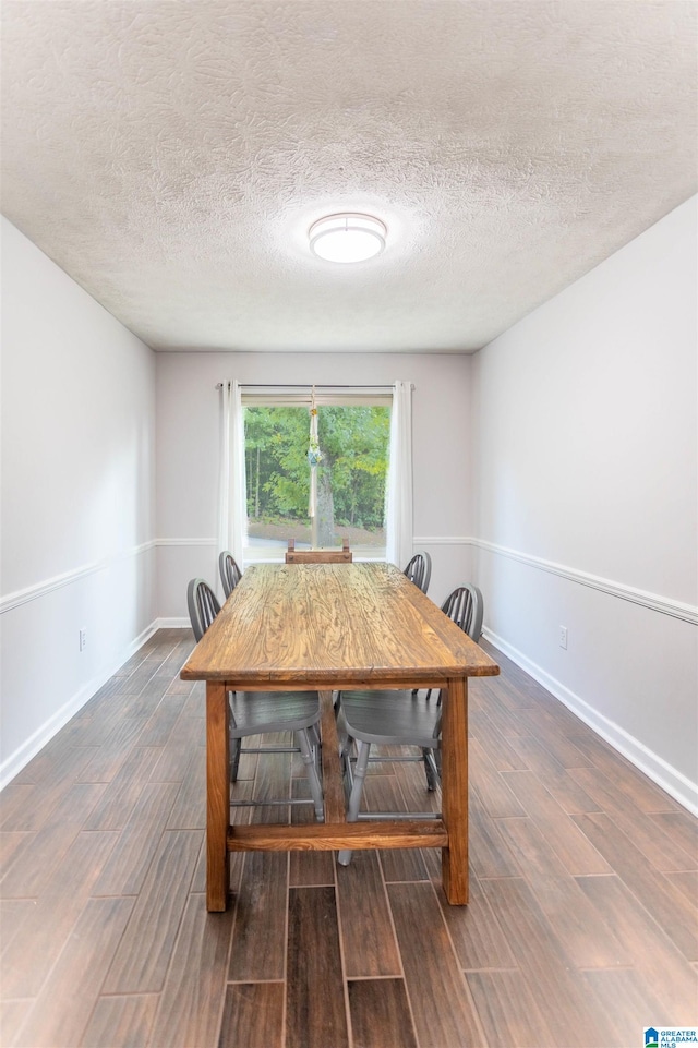 dining area with dark hardwood / wood-style flooring and a textured ceiling