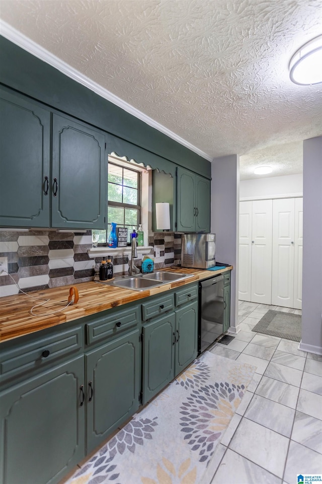 kitchen featuring tasteful backsplash, a textured ceiling, light tile patterned floors, wood counters, and sink