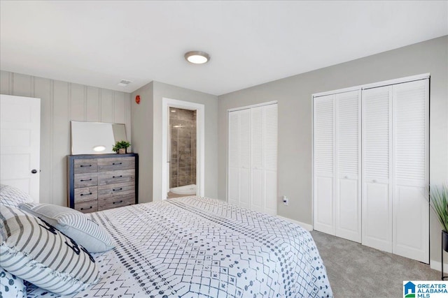 carpeted bedroom with ensuite bathroom and multiple closets