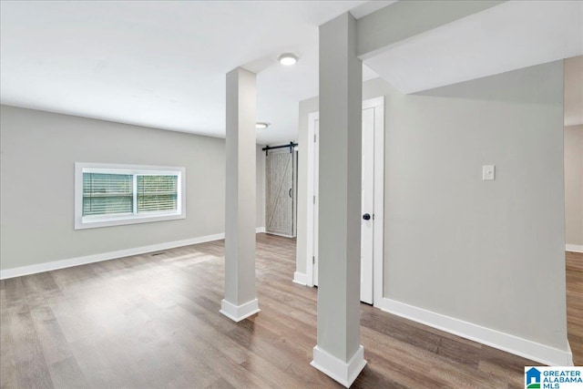 basement featuring hardwood / wood-style floors and a barn door