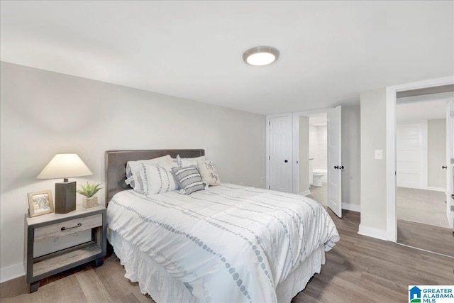 bedroom featuring wood-type flooring and ensuite bath