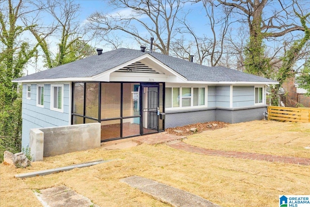 view of front facade featuring a sunroom and a front lawn