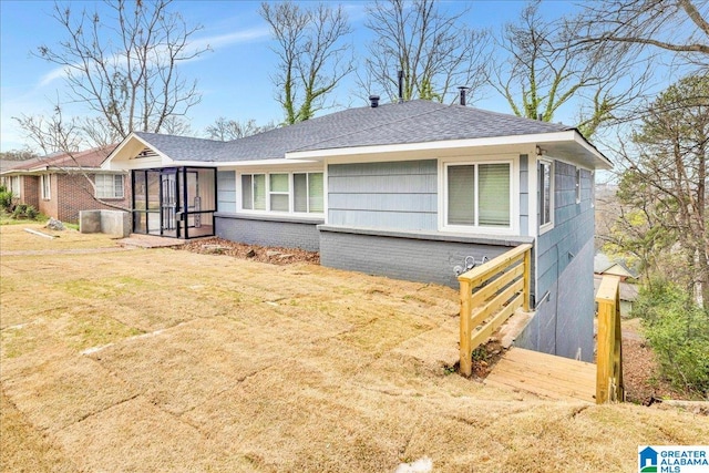 ranch-style home featuring a front lawn and a sunroom