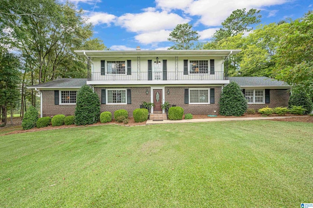 view of front of home with a balcony and a front yard