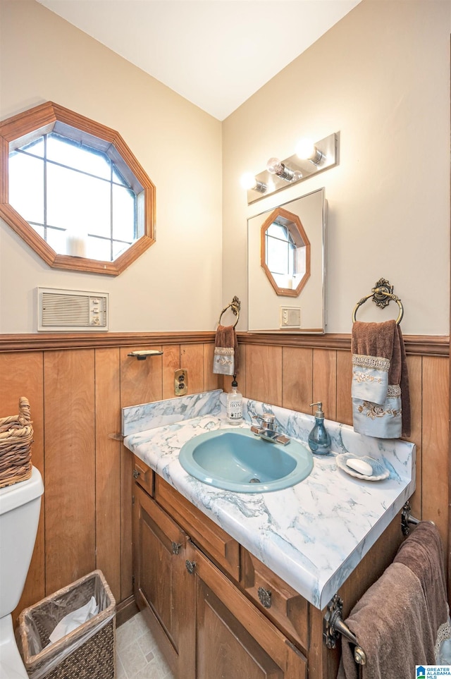 bathroom featuring vanity, toilet, wood walls, and tile patterned floors