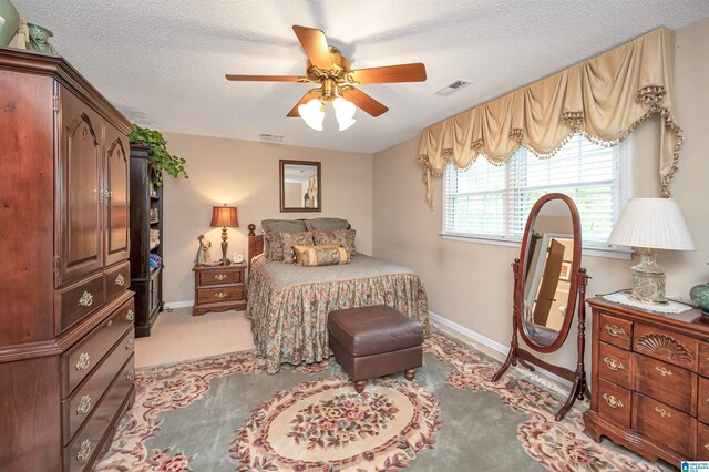 carpeted bedroom with a textured ceiling and ceiling fan