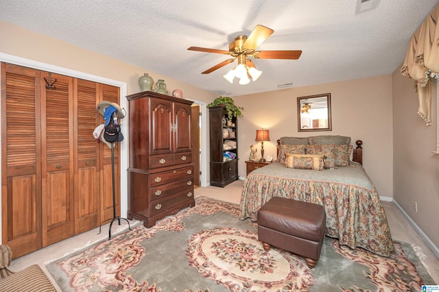 carpeted bedroom featuring a closet, ceiling fan, and a textured ceiling