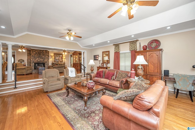 living room with lofted ceiling, light hardwood / wood-style floors, ceiling fan, and a fireplace