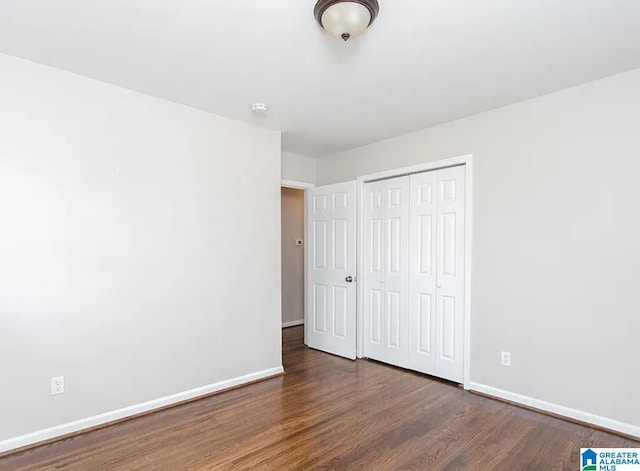 unfurnished bedroom featuring a closet and dark hardwood / wood-style flooring