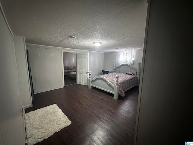 bedroom featuring a textured ceiling and dark hardwood / wood-style floors