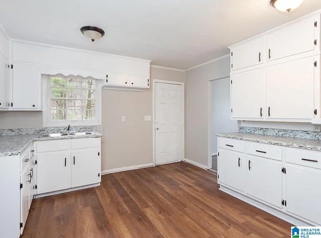 kitchen with dark wood-style flooring, white cabinetry, and crown molding