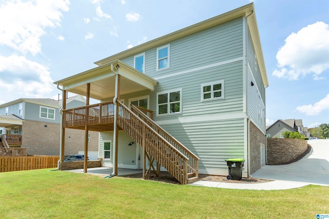 back of property with a yard, a patio, and a deck