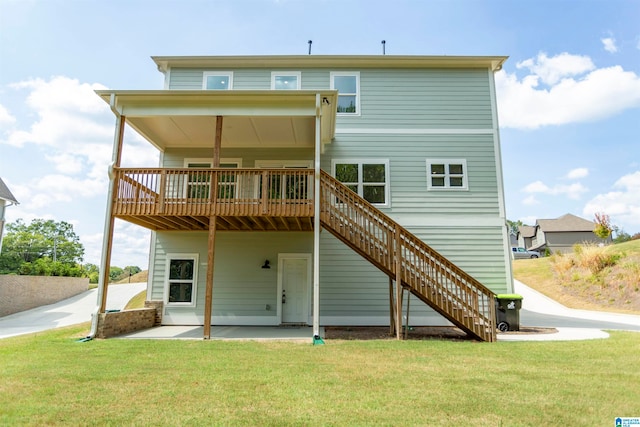 back of house with a wooden deck, a lawn, and a patio