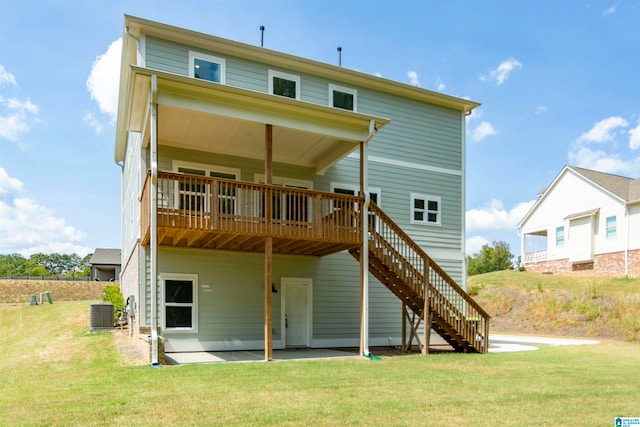 rear view of property featuring central air condition unit, a yard, a patio area, and a deck