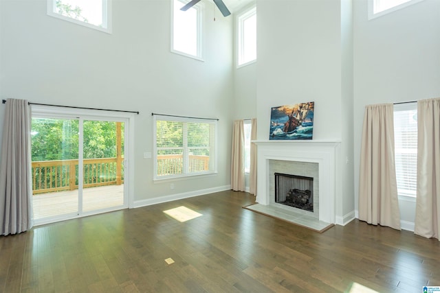 unfurnished living room featuring dark wood-type flooring, ceiling fan, and plenty of natural light