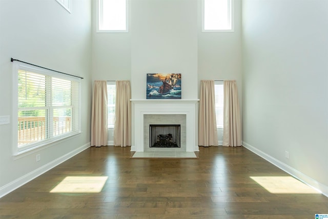 unfurnished living room featuring a healthy amount of sunlight and dark hardwood / wood-style flooring