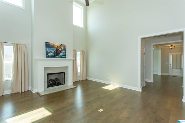 unfurnished living room featuring plenty of natural light and dark hardwood / wood-style floors