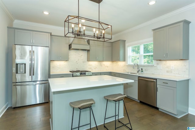 kitchen with a chandelier, stainless steel appliances, dark hardwood / wood-style flooring, a kitchen island, and custom range hood