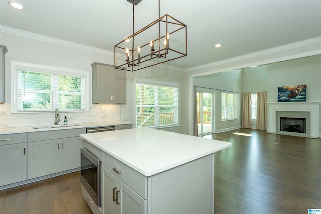 kitchen with sink, stainless steel microwave, dark hardwood / wood-style flooring, and a notable chandelier