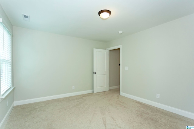 unfurnished room featuring light carpet and a healthy amount of sunlight