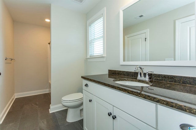 bathroom with vanity, toilet, walk in shower, and tile patterned flooring