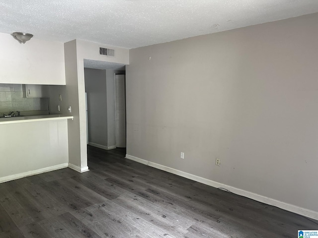 interior space with dark wood-type flooring and a textured ceiling