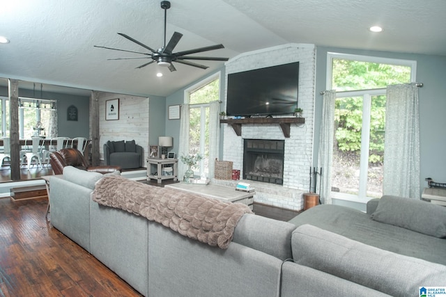 living room with a fireplace, dark hardwood / wood-style flooring, plenty of natural light, and lofted ceiling