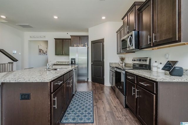 kitchen featuring dark wood-type flooring, light stone countertops, stainless steel appliances, and sink