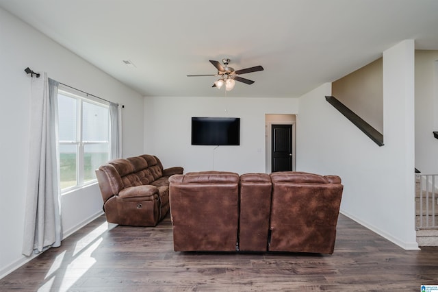 living room featuring ceiling fan and dark hardwood / wood-style floors