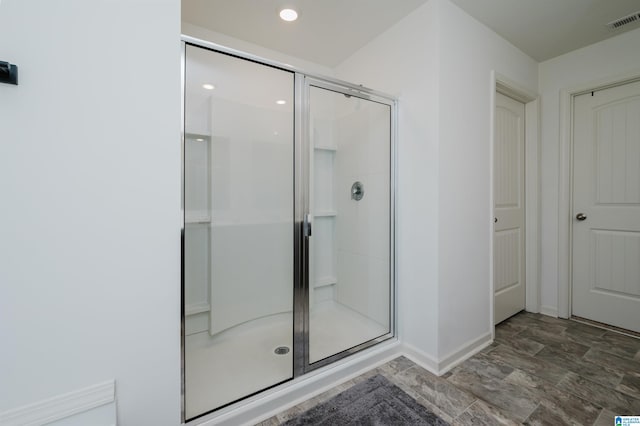 bathroom with a shower with door