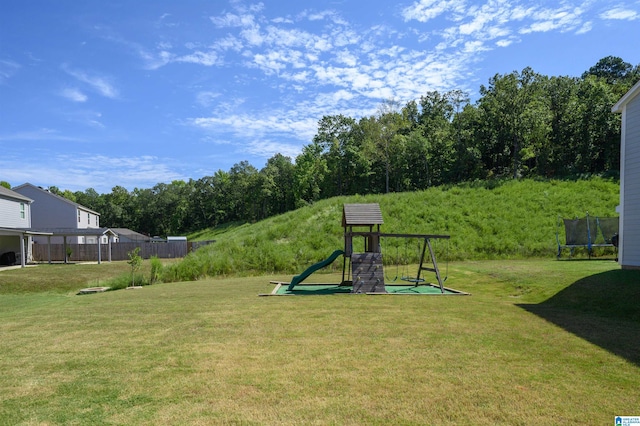 view of yard with a trampoline and a playground