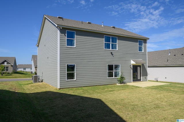 rear view of property with a patio area, a yard, and central AC