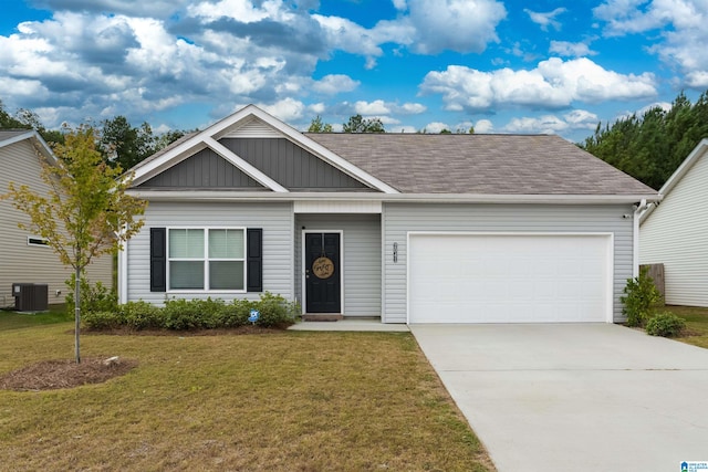 view of front of home with a garage, central AC, and a front yard