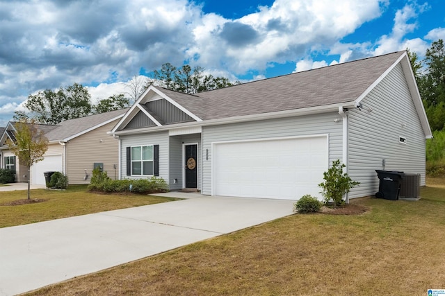 view of front of house featuring a garage, a front yard, and central AC