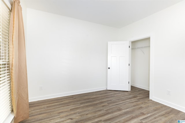 unfurnished bedroom with hardwood / wood-style floors and a closet