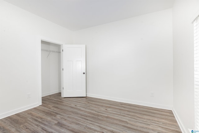 unfurnished bedroom with a closet and hardwood / wood-style flooring