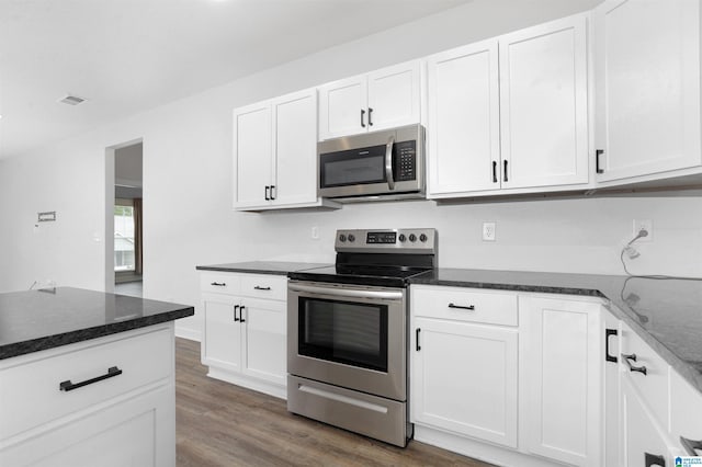 kitchen with dark hardwood / wood-style flooring, stainless steel appliances, and white cabinets