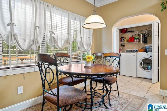 dining space with crown molding, washer and dryer, light tile patterned flooring, and a healthy amount of sunlight