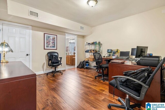 home office with visible vents, wood finished floors, and baseboards
