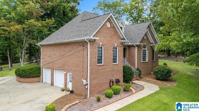 view of side of home with concrete driveway, roof with shingles, a garage, and brick siding