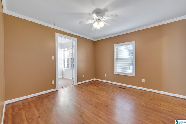 spare room with ceiling fan, crown molding, and wood-type flooring