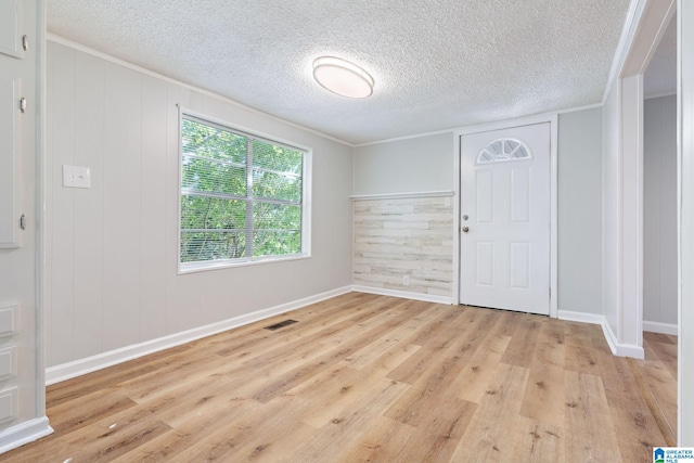 entryway featuring a textured ceiling, light hardwood / wood-style flooring, and wood walls