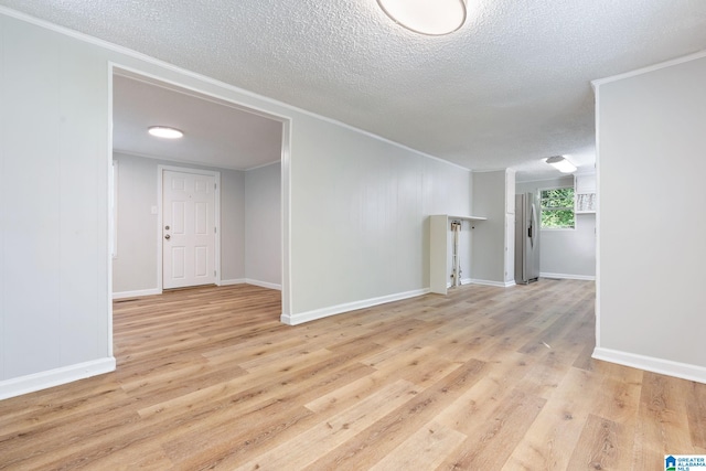 spare room with light hardwood / wood-style floors and a textured ceiling